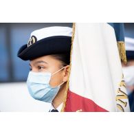 Portrait du porte-drapeau féminin de l'école de maistrance pendant les derniers préparatifs avant le défilé à pied du 14 juillet sur la place de la Concorde.