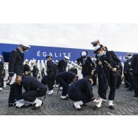 Derniers préparatifs pour les élèves de l'école navale qui ajustent leurs guêtres avant la cérémonie du 14 juillet sur la place de la Concorde.