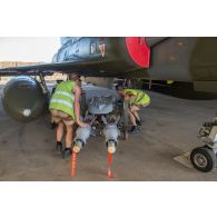 Des mécaniciens armement opérationnel montent des bombes GBU 49 sur un avion Mirage 2000D de l'escadron de chasse 1/3 Navarre à N'Djamena, au Tchad.