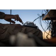 Un transmetteur communique en code morse à bord d'un véhicule léger de reconnaissance et d'appui (VLRA) un moyen d’élongation pour les communications hautes fréquences interarmées et OTAN en réseau (MELCHIOR) sur l'axe Berliet, au Niger.