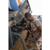 Le brigadier-chef Julien, conducteur-ravitailleur, raccorde une pompe pour le transfert du carburant livré par l'entreprise Total sur le site d'exploitation du Service des essences des armées (SEA) à Niamey, au Niger.