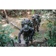 Des soldats du 7e bataillon de chasseurs alpins (BCA) franchissent un marécage à Maripasoula, en Guyane française.