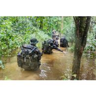 Des soldats du 7e bataillon de chasseurs alpins (BCA) franchissent un marécage à Maripasoula, en Guyane française.