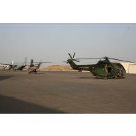 Déploiement de l'opération de la force européenne EUFOR Tchad/RCA (République centrafricaine) : un hélicoptère de transport Puma SA-330 est remorqué alors qu'un autre décolle sur la base aérienne 172 sergent-chef Adji Kosseï à N'Djamena.