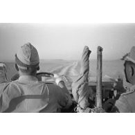 Le photographe qu'on aperçoit dans le rétroviseur, photographie le chauffeur et le chef de bord d'une Horch Kfz.15, un fusil britannique Lee-Enfield est posé au centre du véhicule.