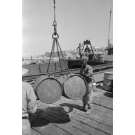 Activités dans le port de Tobrouk, déchargement d'essence (jerrycans et futs) par des prisonniers alliés.