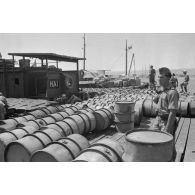 Activités dans le port de Tobrouk, déchargement d'essence (jerrycans et futs) par des prisonniers alliés.