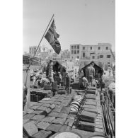 Activités dans le port de Tobrouk, déchargement d'essence (jerrycans et futs) par des prisonniers alliés.