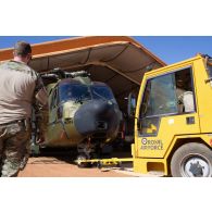 Tractage d'un hélicoptère danois Merlin EH 101 dans un hangar de la base de Gao, au Mali.