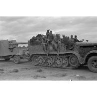 Progression d'un semi-chenillé Sd.kfz.7 tractant une pièce de 8,8 cm FlaK.