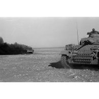 Un Panzer III de commandement (Befehlpanzer III) se rapproche d'un char britannique Matilda en feu.