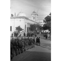 A Tunis, entouré par des enfants, un défilé de troupes aéroportées allemandes dans les rues.