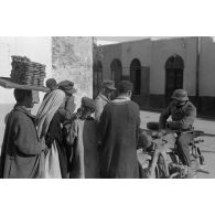 A Kairouan, des fantassins allemands achètent des produits locaux, sur la droite un side-car KS-750.