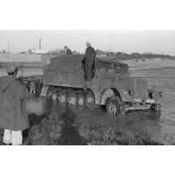 Dépannage d'un véhicule britannique par un semi-chenillé Sd.kfz.7, on note l'inscription Gruppe Hägele sur le blindé allemand.