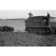 Dépannage d'un véhicule britannique par un semi-chenillé Sd.kfz.7, on note l'inscription Gruppe Hägele sur le blindé allemand.