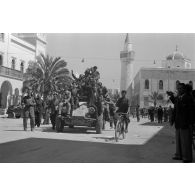 Des civils italiens sont juchés sur un blindé SdKfz-222 qui traverse Benghazi.