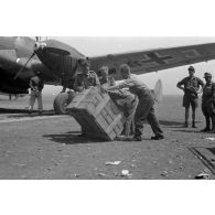 Un bimoteur Messerschmitt Bf-110 F1-R2 du Zerstörergeschwader 26 (ZG-26) sur un aérodrome de campagne. Déchargement de caisses.