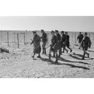 Le général (Generalleutnant) Erwin Rommel inspecte un réseau de fils barbelés en compagnie d'officiers allemands et italiens.