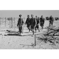 Le général (Generalleutnant) Erwin Rommel inspecte un réseau de fils barbelés en compagnie d'officiers allemands et italiens.