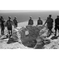 Le général Erwin Rommel, accompagné d'officiers italiens et allemands, observe la mer à partir d'une position retranchée italienne.