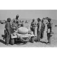 Le colonel (Oberst) Alfred Bruer commandant du Panzer-Artillerie-Regiment 155 de la 21. Panzer-Division, debout dans une voiture Kübelwagen, parle avec ses officiers.