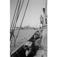 Des soldats italiens mangent sur le pont d'un bateau.