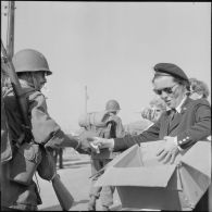 Distribution de confiseries et cigarettes par la Croix-Rouge aux soldats d'un contingent débarquant à Bône.