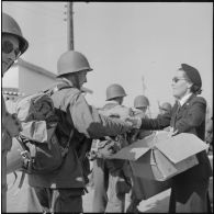 Distribution de confiseries et cigarettes par la Croix-Rouge aux soldats d'un contingent débarquant à Bône.