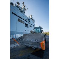 Un marin guide le chargement d'un bulldozer du Génie à bord du bâtiment de projection et de commandement (BPC) Le Tonnerre à Toulon.