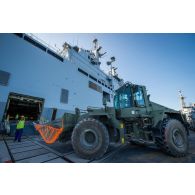 Un marin guide le chargement d'un bulldozer du Génie à bord du bâtiment de projection et de commandement (BPC) Le Tonnerre à Toulon.