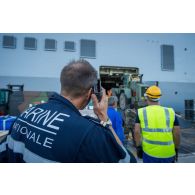 Une enseigne de vaisseau de 1re classe encadre le chargement d'un bulldozer du Génie à bord du bâtiment de projection et de commandement (BPC) Le Tonnerre à Toulon.