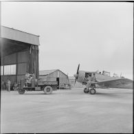 Tracteur menant un avion North American T6 aux ateliers de révision.