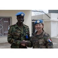 Photographie de groupe d'un capitaine féminin français et d'un militaire ghanéen des CIMIC.