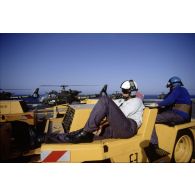 Personnel de pont assis en attente sur des tracteurs sur le pont d'envol du PA (porte-avions) Clemenceau.