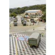 Des logisticiens du 519e groupe de transit maritime (519e GTM) encadrent le chargement d'un camion-citerne CBH-385 sur un quai du port de Toulon.