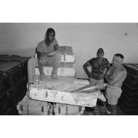 Un jeune garçon tchadien pose sur des caisses en bois à l'insigne du croissant rouge qui contiennent des obus d'origine libyenne.