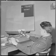 Algérie. 5e bureau. Un stagiaire officier regarde une photo pour la création d'une affiche de propagande.