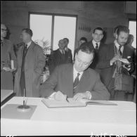 Alger. Hôtel de ville. Michel Debré écrit un mot dans le livre d'or.