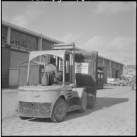 Port d'Alger. Chariot élévateur transportant un container de livres scolaires.