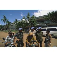 Trois observateurs militaires de l'ONU, deux russes et un algérien, échangent avec des cambodgiens dans la rue à Srae Ambel.