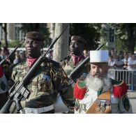 Un pionnier de la Légion étrangère défile aux côtés des tirailleurs sénégalais sur les Champs-Elysées à Paris.