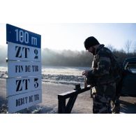 Le photographe Simon garnit les chargeurs de son fusil d'assaut FAMAS sur le champ de tir de Montmorency.