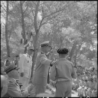 Le général d'armée aérienne Challe, commandant en chef des Forces armées en Algérie, félicite un élève qui vient de recevoir le grand prix d'honneur offert par le ministre des Armées, à l'occasion de la cérémonie de distribution solennelle des prix de l'Ecole militaire préparatoire nord-africaine (EMPNA) de Koléa, sous le regard du lieutenant-colonel Rouvière, commandant de l'Ecole.