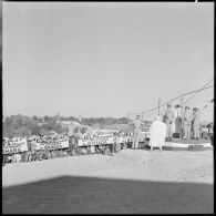 Plan large sur la foule face au maire de Djelfa pendant son discours, qui brandit des banderoles pour le rattachement de Djelfa au Sahara.