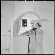 Portrait d'une jeune femme qui parle au téléphone de la cabine téléphonique de la section administrative spécialisée (SAS) du Zaccar.