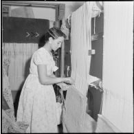 Portrait d'une jeune fille qui confectionne un tapis.