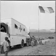 Rassemblement de la population du centre de regroupement de Talouine, situé dans la vallée de l'Oued Isser, devant le camion de la Croix-Rouge française.