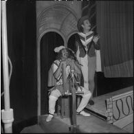 Portrait de deux comédiens sur scène à l'occasion de la répétition générale de la comédie Volpone, du dramaturge anglais Ben Johnson, devant des officiers, sous-officiers et hommes de troupe de la 428e Compagnie de réparation divisionnaire (428e CRD).