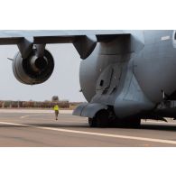 Un soldat du détachement de transit interarmées (DéTIA) guide l'arrivée d'un avion Boeing C-17 émirati sur l'aéroport de Gao, au Mali.