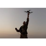 Un soldat lance un micro-drone DJI Mavic Pro pour surveiller le périmètre d'un campement dans la région de Gao, au Mali.